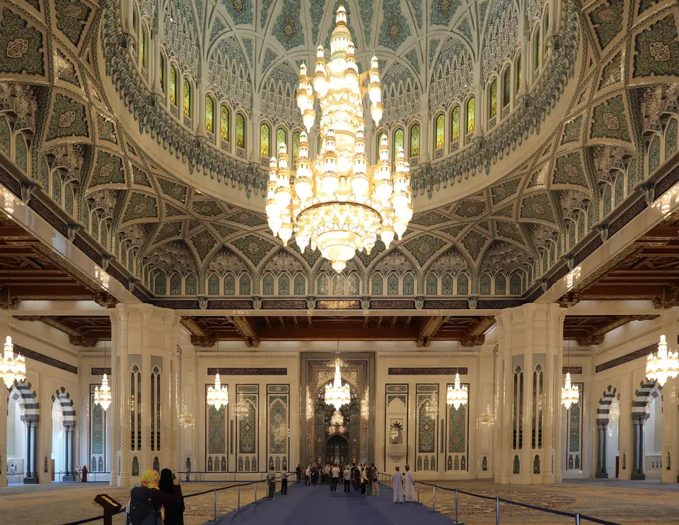 A large chandelier hanging in the ornate main prayer hall of the Sultan Qaboos Grand Mosque.